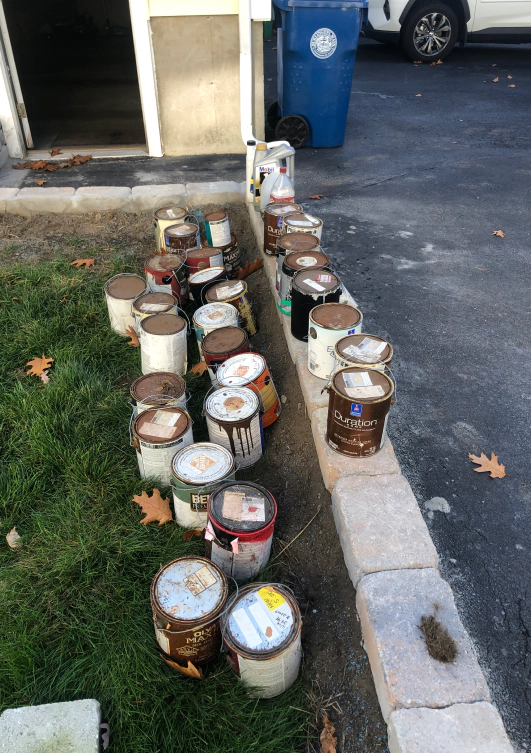 paint buckets junk outside of a house